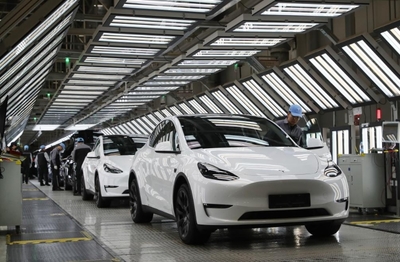 2023年12月22日,在特斯拉上海超級工廠內,工人在對出廠前的車輛進行漆面及門窗檢測。新華社記者方喆攝